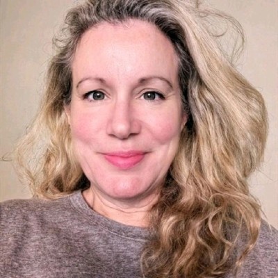 Colour photo of Natalie Smithson looking straight to camera in grey T-shirt